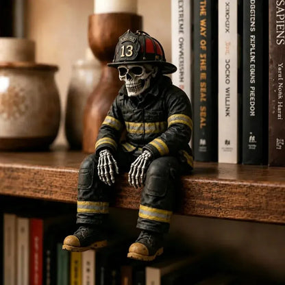 A skeleton figurine dressed as a firefighter sits on a wooden shelf in front of a row of books. The figure wears a black helmet with the number 13, a black uniform with yellow stripes, and tan boots.